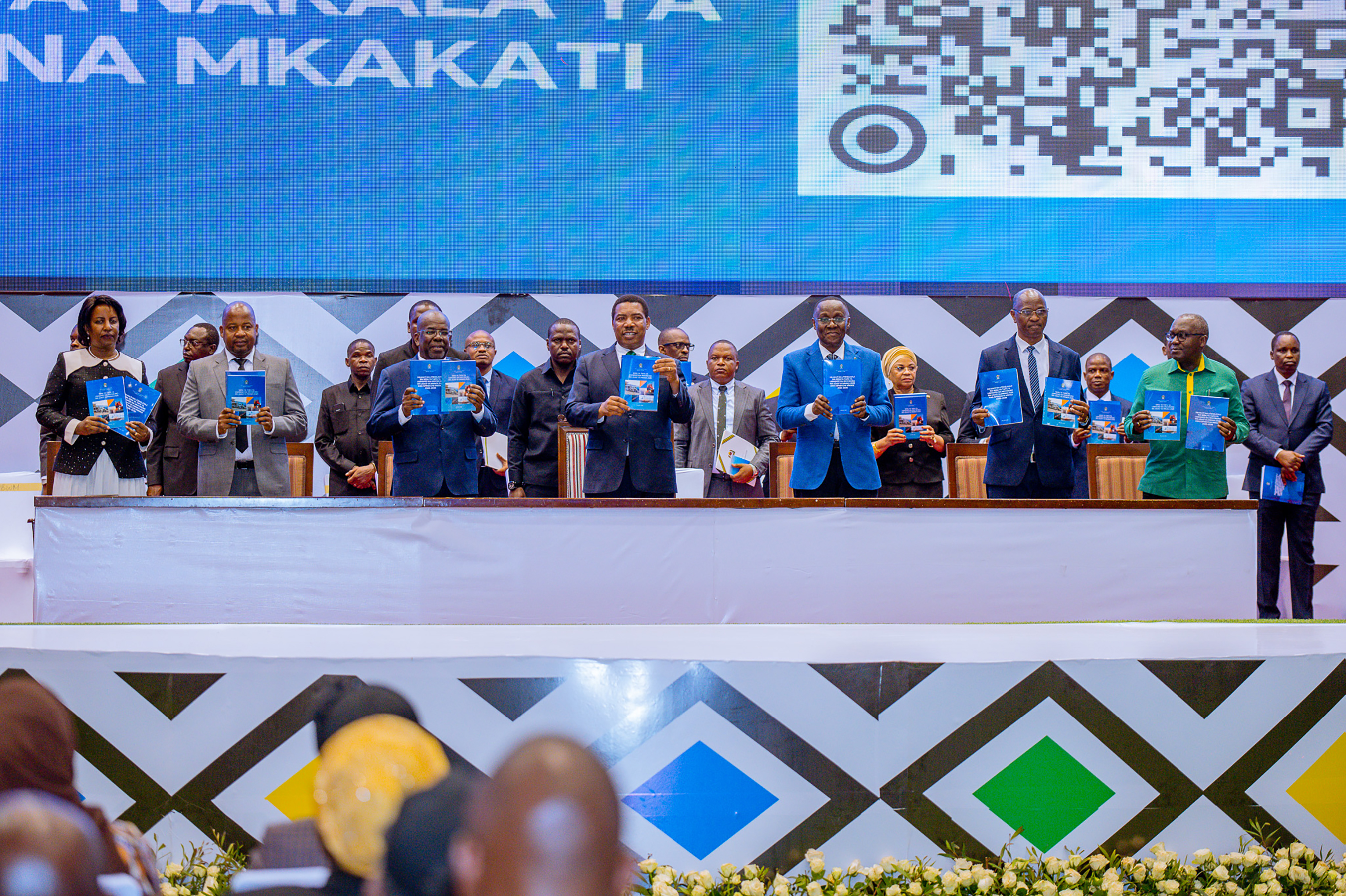 Meza Kuu ikiongozwa na Mgeni Rasmi Waziri Mkuu wa Jamhuri ya Muungano wa Tanzania, Mhe. Dkt. Mwigulu Lameck Nchemba (Mb), wakionesha Vitabu vya Sera Taifa ya Usimamizi wa Mnyororo wa Ugavi ya Mwaka 2025 na Mkakati Wa Utekelezaji wa Sera ya Taifa ya Usimamizi wa Mnyororo wa Ugavi ya Mwaka 2025 kwa Kipindi Cha Mwaka 2026–2036, wakati wa hafla ya uzinduzi wa Sera hiyo katika Ukumbi wa Mikutano wa Jakaya Kikwete, jijini Dodoma.